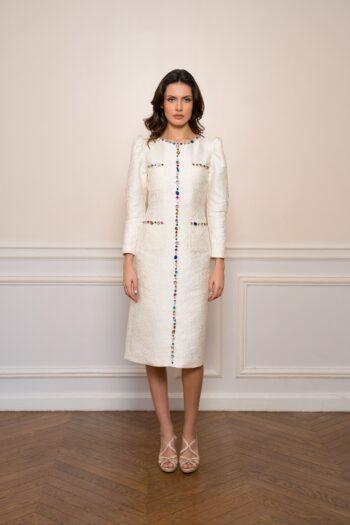 Cream-colored, straight-cut dress in textured brocade embellished with colorful rhinestones.