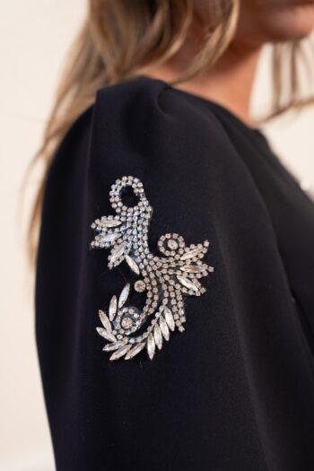 détail manche robe noire bijoux