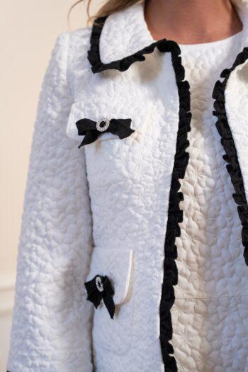 Détail de la veste Gigi en jacquard texturé avec finitions contrastées et nœud décoratif